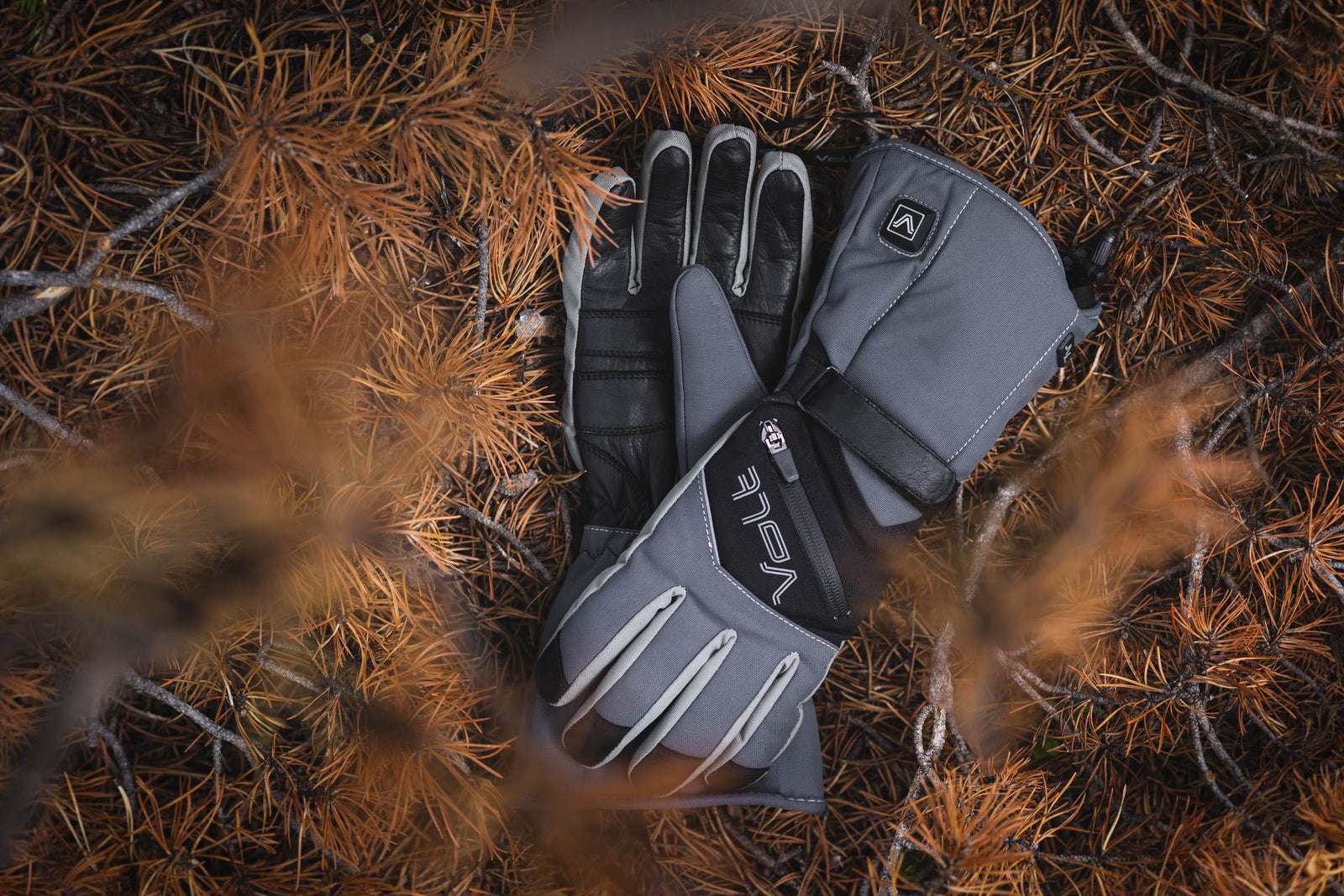 Heated winter gloves placed on grass, showcasing new and favorite products