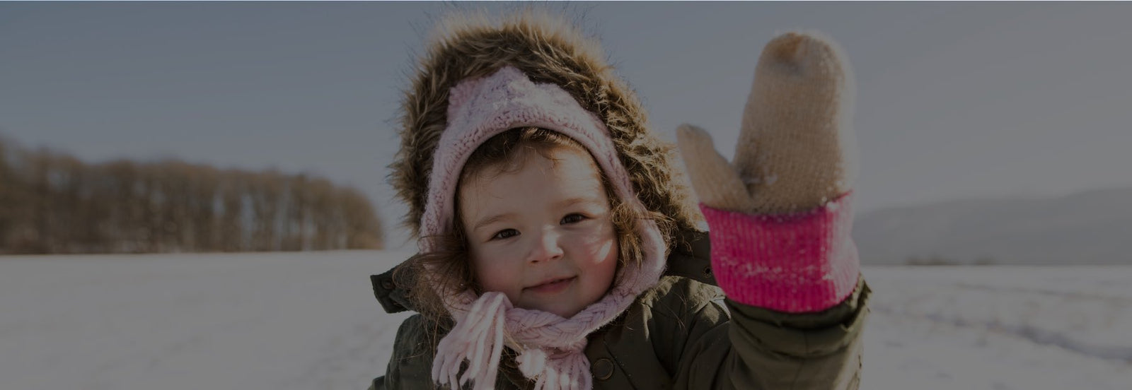 Child standing in the snow wearing heated gloves
