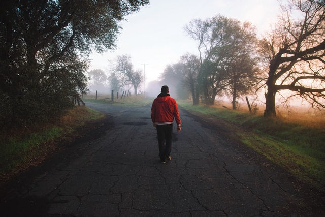 Man walking down a winter road wearing a heated tactical base layer heated cloth