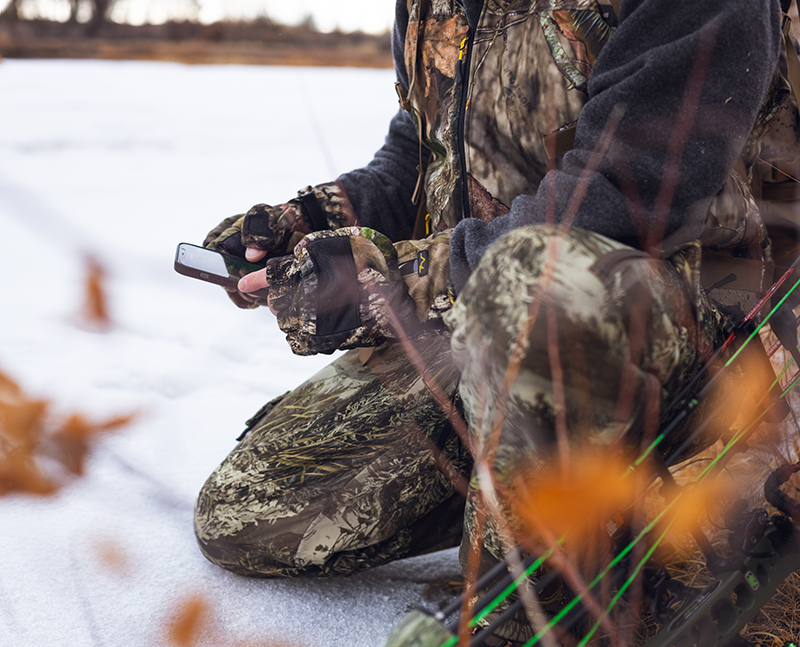Volt rechargeable battery powered Heated Camo Flip Mitts using touchscreen on  phone lifestyle